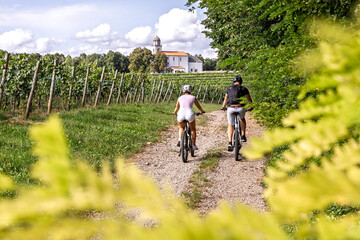 Couple cycling through Karst vineyards in Komen