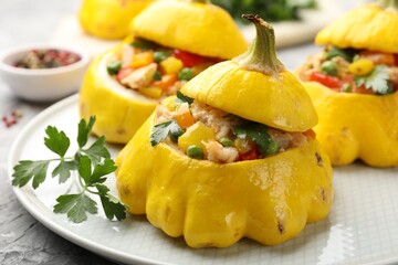 Tasty stuffed pattypan squashes on grey textured table, closeup