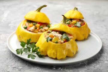 Tasty stuffed pattypan squashes on grey textured table, closeup