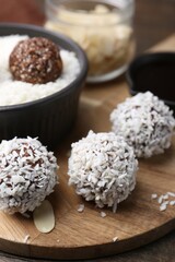 Delicious homemade candies with coconut flakes on table, closeup