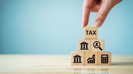 Hand arranging tax blocks with financial icons, representing accounting, analysis, and business success