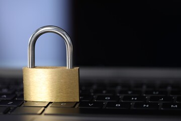Cyber safety. Metal padlock on laptop, closeup. Space for text