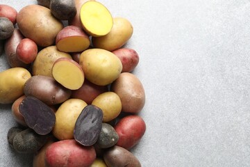 Different types of potatoes on grey table, flat lay. Space for text