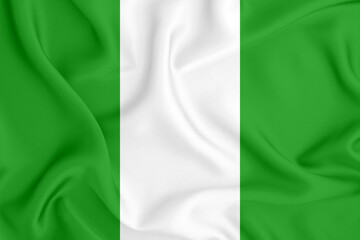 flag of the Federal Republic of Nigeria with three vertical stripes of two colors on satin fabric with folds and shadows
