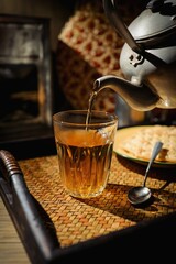 Hot tea ,Pouring tea from the kettle on wooden blackground, retro style	