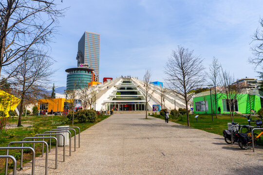 Tirana, Albania, 22 March 2025 - The renovated piramd of Tirana with tourist climbing the stairs.