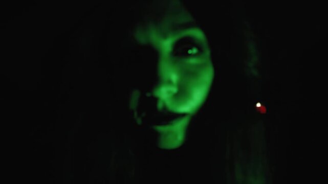 The witch with the green skin looks and comes closer, a smirk on her face.