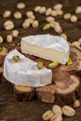 peeled green crunchy pistachios and cheese in a white mold, delicious white soft cheese in a mold cut in the center and salted pistachios with and without cracked shells