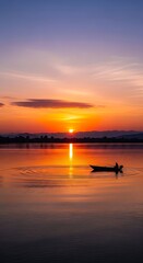 Sunrise over tranquil lake with small boat