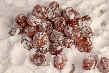 dried kumquat and powdered white sugar, sweet dried orange kumquat fruits in white powdered sugar