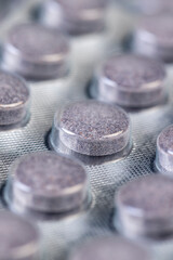 cylindrical purple tablets made from natural ingredients packed in a blister , whole purple tablets packed in a metal-plastic blister with the addition of blueberry extract and other ingredients