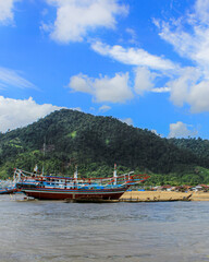 Traditional Fishing Boat on Beach with Mountain Background