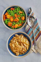 simmered chicken thighs in brown gravy served with steamed carrots and peas