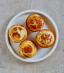 cinnamon cauliflower swirl muffins topped with lemon icing, isolated overhead angle