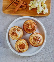cinnamon cauliflower swirl muffins topped with lemon icing