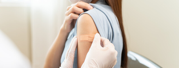 People getting a vaccination to prevent pandemic concept. Woman in medical face mask  receiving a dose of immunization coronavirus vaccine from a nurse at the medical center hospital