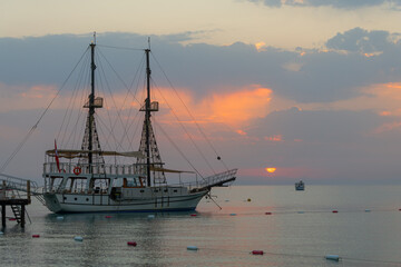 Naklejka premium A pleasure yacht with two masts at its berth in the Turkish province of Antalya on a picturesque early summer morning