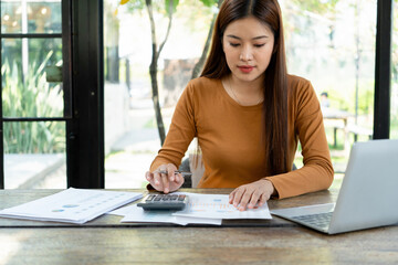Young woman engages in note-taking at workspace.