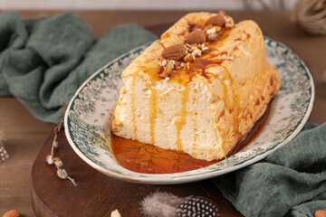 A softly focused shot presents a traditional caramelized egg white pudding known as molotof or molotov, generously drizzled with rich caramel and adorned with whole and chopped almonds