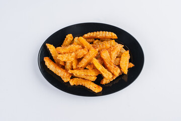 Crispy seasoned potato fries on a black plate, overhead view. Golden brown, seasoned with spices.