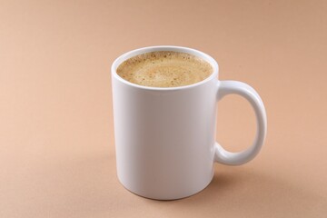 Aromatic coffee in cup on beige background, closeup. Mockup for design