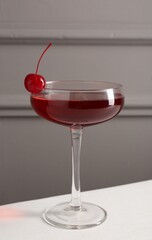 Tasty cherry cocktail on white table, closeup