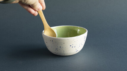 Clay bowl over it stir with wooden spoon hand
