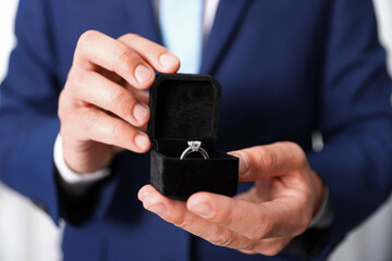 Making proposal. Man with engagement ring indoors, closeup