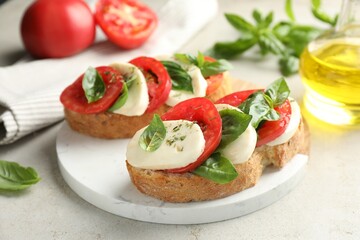 Delicious sandwiches with mozzarella cheese, tomatoes and basil on light grey table, closeup