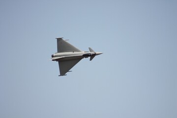 Modern fighter jet soaring through the clear blue sky, showcasing power and speed
