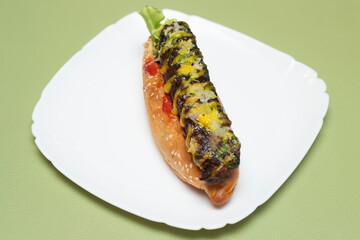 BBQ chicken hot dog with melted cheese and fresh lettuce on a white plate side view of Bangladeshi food