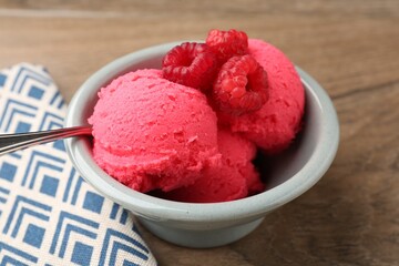 Delicious raspberry sorbet with fresh berries in bowl on wooden table, closeup