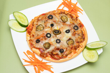 BBQ chicken pizza topped with olives and salad on a white plate side view of Bangladeshi food