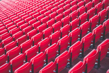 Fototapeta premium Rows of vibrant red stadium seats creating a pattern, ready for the excited crowd to arrive
