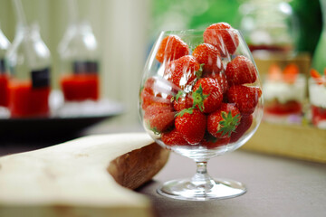 Delightful display of fresh strawberries in elegant glass ready for summer entertaining and healthy...