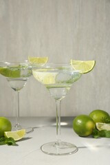 Martini cocktails with lime and mint on grey table, closeup
