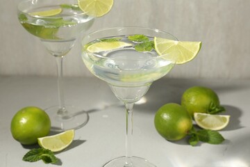 Martini cocktails with lime and mint on grey table, closeup