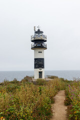 Ribadeo Lighthouse captured from Isla Pancha beach, Galicia, Spain. Stunning coastal landscape with the iconic lighthouse standing tall by the Atlantic Ocean.