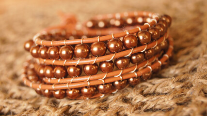 braided leather bracelet with glass beads brown on knitted surface