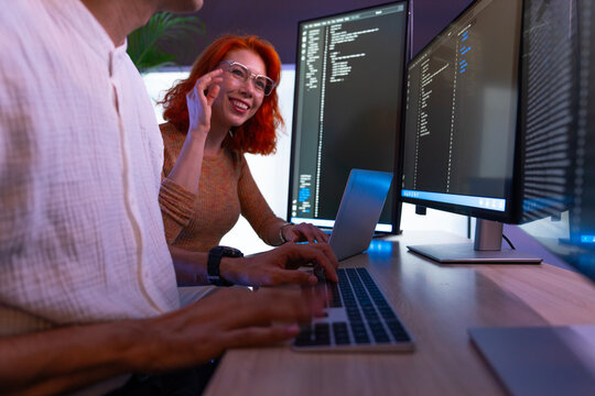 female programmer is coding a hologram at night, working on data analytics, information technology, malware, or software at the office. A staff developer is working late in a computer display in probl