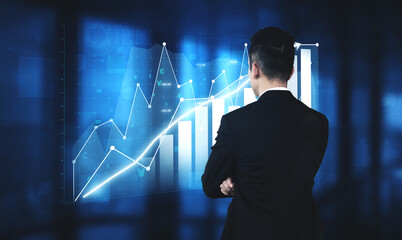 A businessman in a suit observes digital financial growth graphs in a modern office, representing data analytics and strategic business planning. Impute
