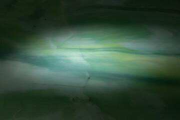 Green and white marbled background with central spotlight illuminating textured canvas for artistic or abstract effect