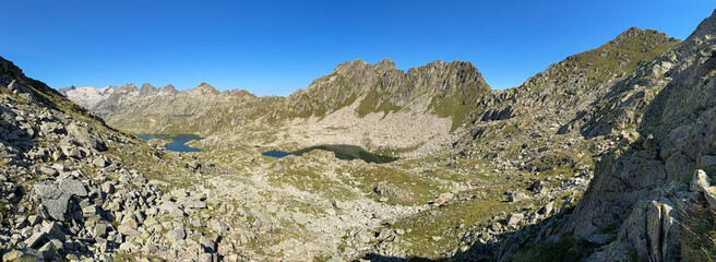 Hiking trail winding through picturesque pyrenees mountains with sparkling lakes.
