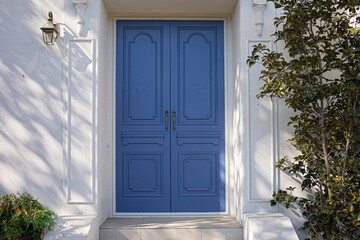 A classic blue door contrasting against a white wall.