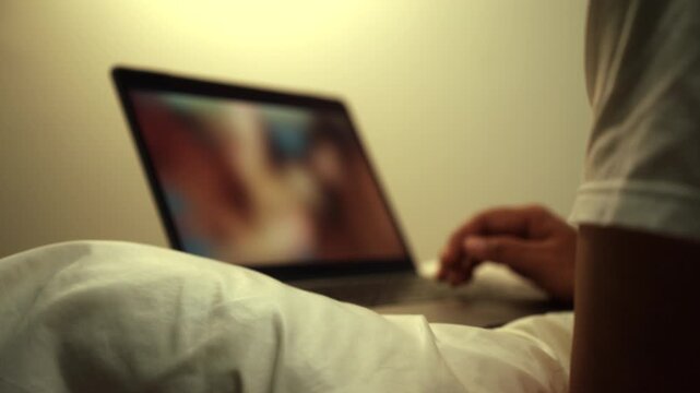 Man scroll porn sites and masturbate watching adult video on the bed with only tissues around him. Loneliness man watching porn site video on a laptop.