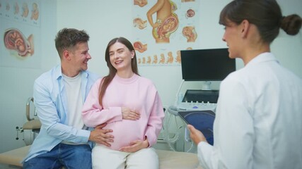 Happy Caucasian couple expecting baby while sitting together in gynecology office during consultation. Man embracing pregnant woman. Holding belly while doctor with tablet talking to them. - Powered by Adobe