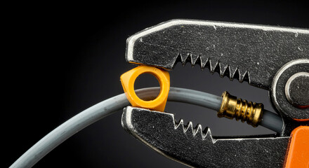 Wire stripper gripping gray electrical wire