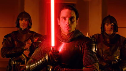 A knight in futuristic armor wields a glowing red lightsaber, flanked by two similarly armored guards in a dramatic, fiery-lit chamber evoking an epic sci-fi scene.