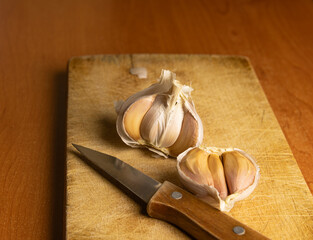 Fresh Garlic Bulbs with Knife on Wooden Cutting Board