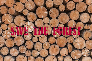 Environmental message with stacked cut logs and bold red text saying "Save the Forest", symbolizing deforestation, sustainability, and the importance of protecting nature